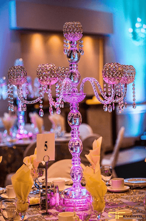 Crystal candelabra centrepiece glowing pink over table 5 with napkin fans