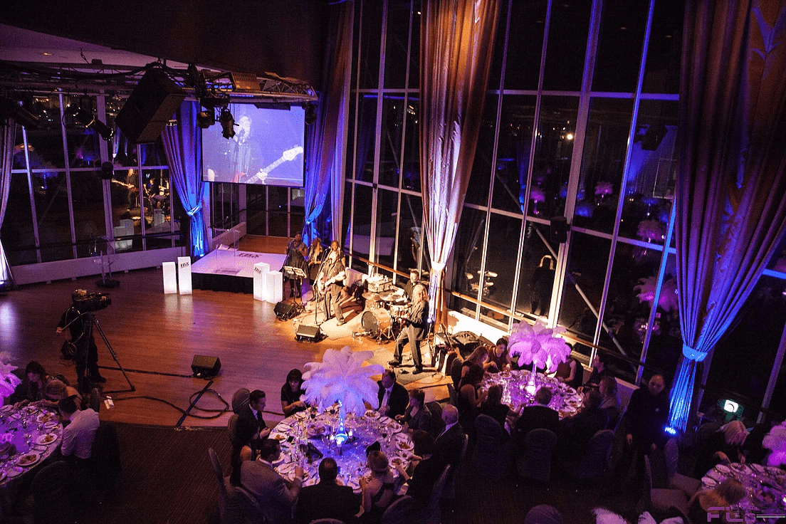Overhead view of band on stage under truss with IMAG screen and feather centrepieces