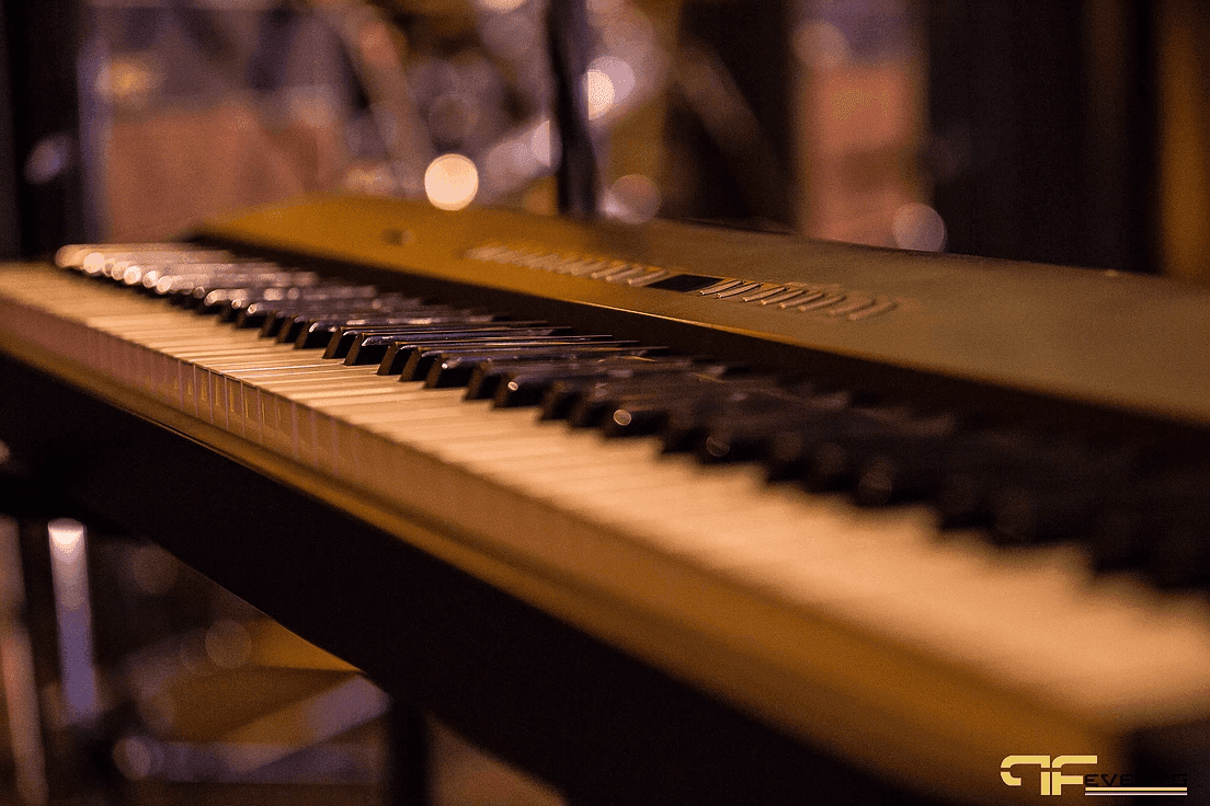 Close-up of stage piano keys under warm amber stage light
