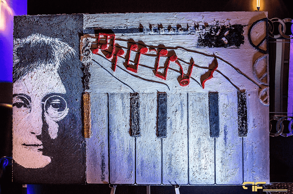 Easel painting of John Lennon with piano keys and red music notes