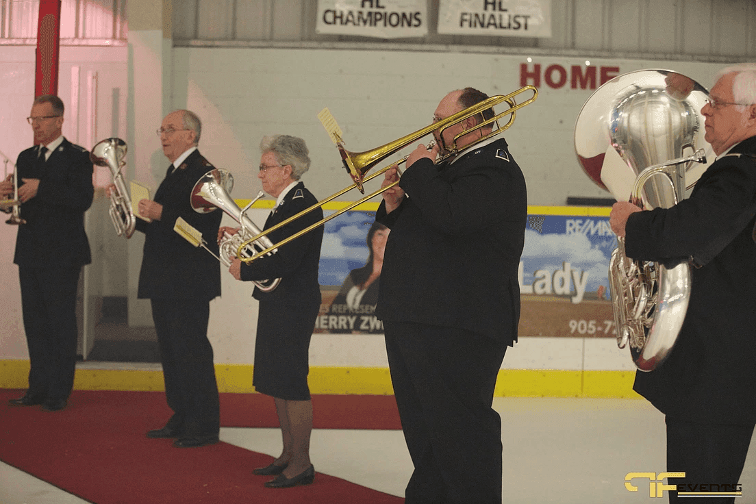 Brass band in uniform playing on a red carpet laid on the ice