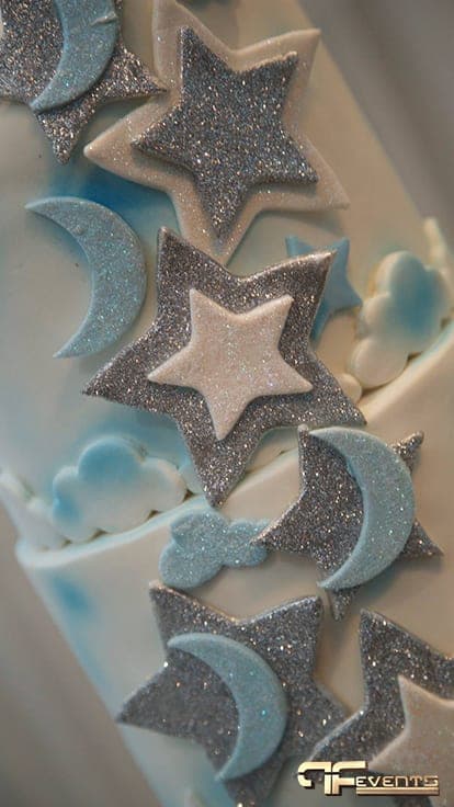 Close-up of glitter star and moon fondant decorations on a birthday cake