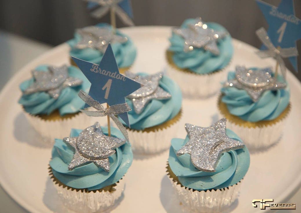 Blue-frosted cupcakes topped with glitter stars and star picks