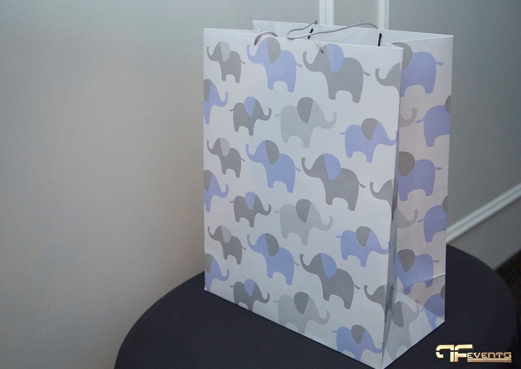 Elephant-print gift bag on a black-draped cocktail table