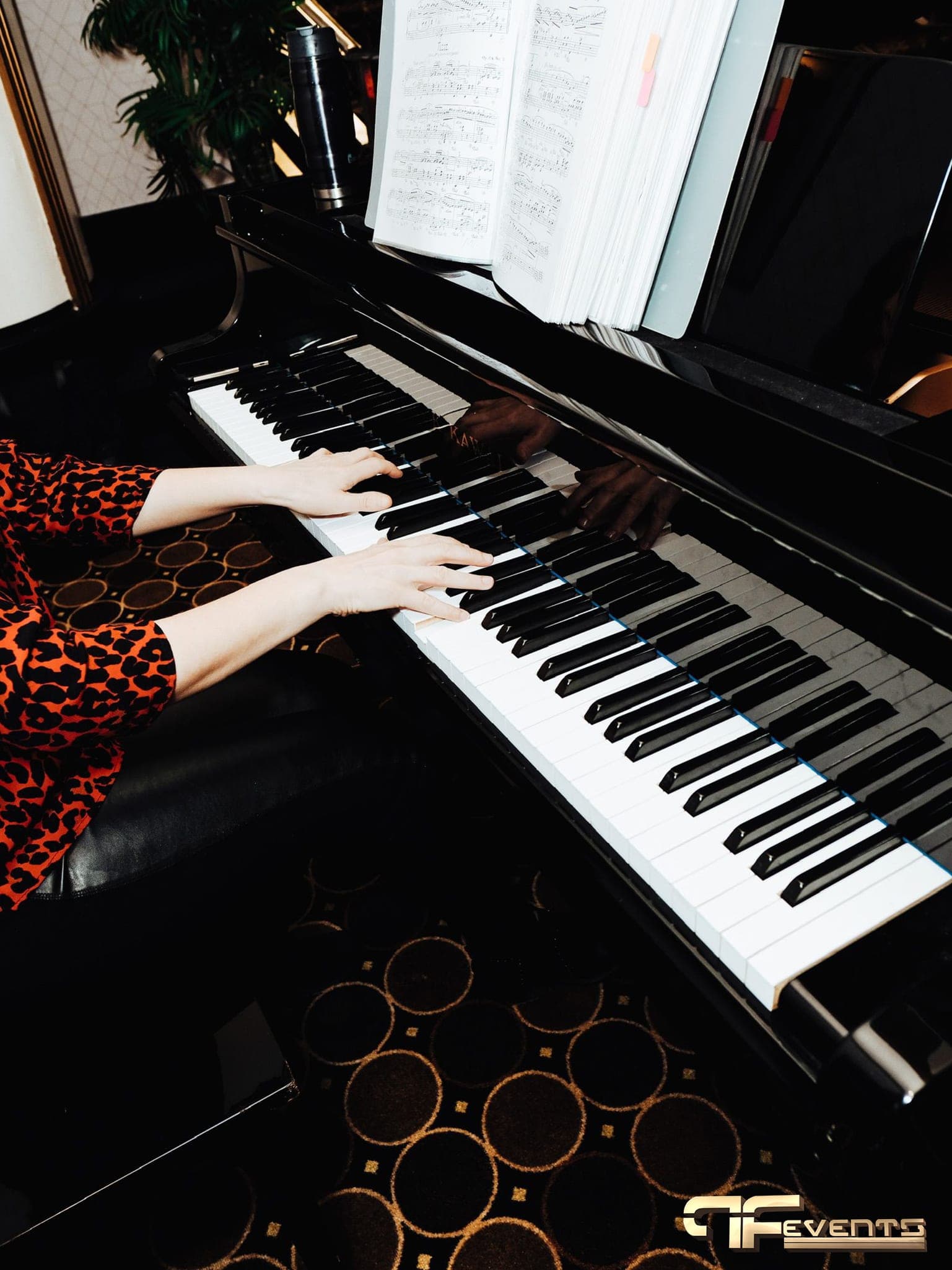Hands on a grand piano keyboard in the Eglinton Grand foyer