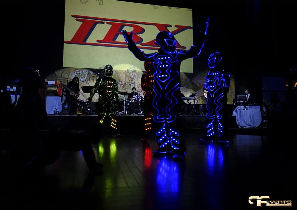 LED light-suit dancers perform under the projected IBX logo