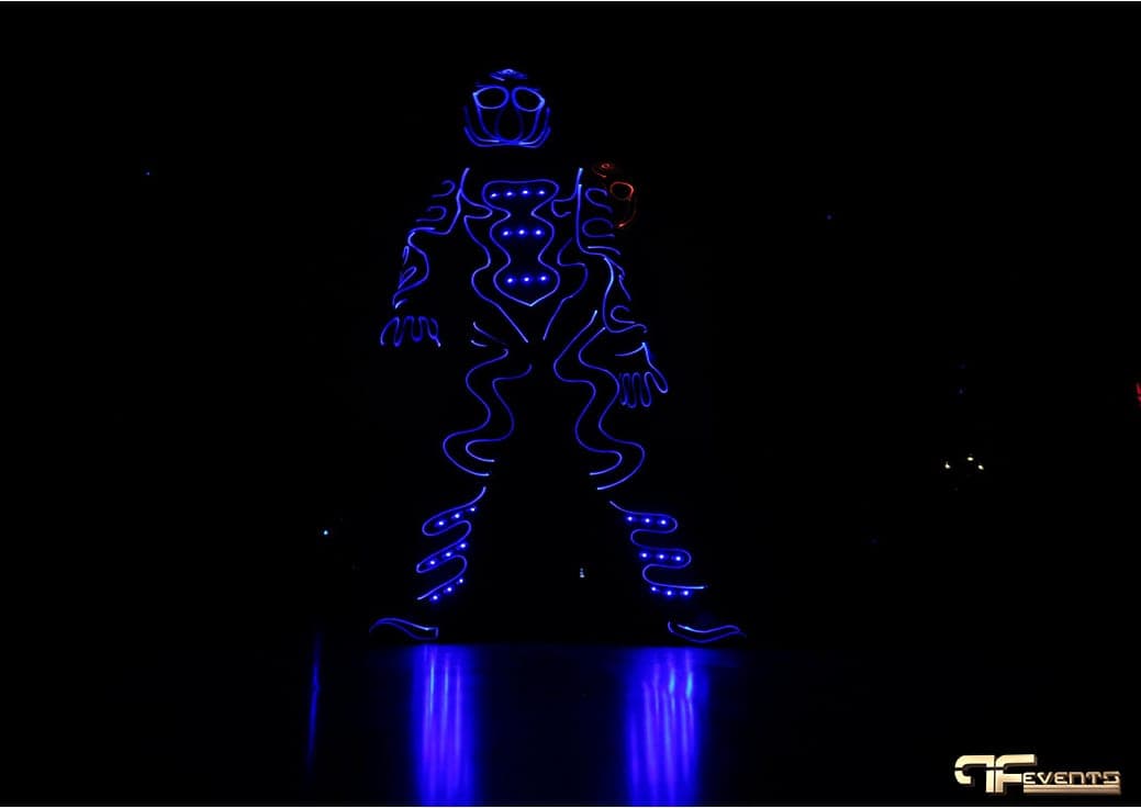 Dancer in a blue LED light suit in a blacked-out room