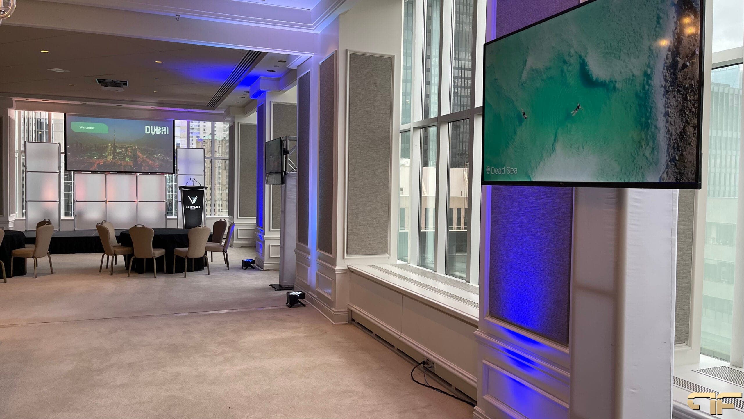 Presentation room with Dubai welcome slide, blue wall washes and Dead Sea video on a TV