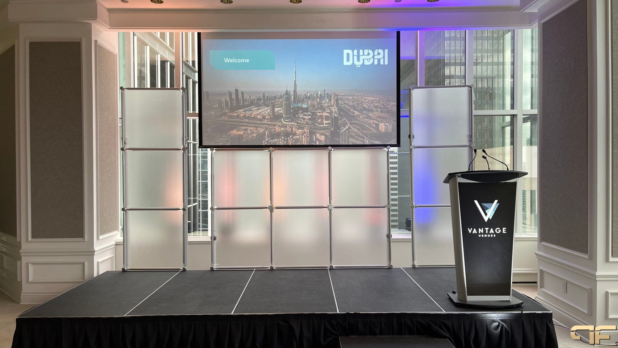 Skirted stage with frosted panel backdrop, Dubai welcome screen and Vantage Venues lectern