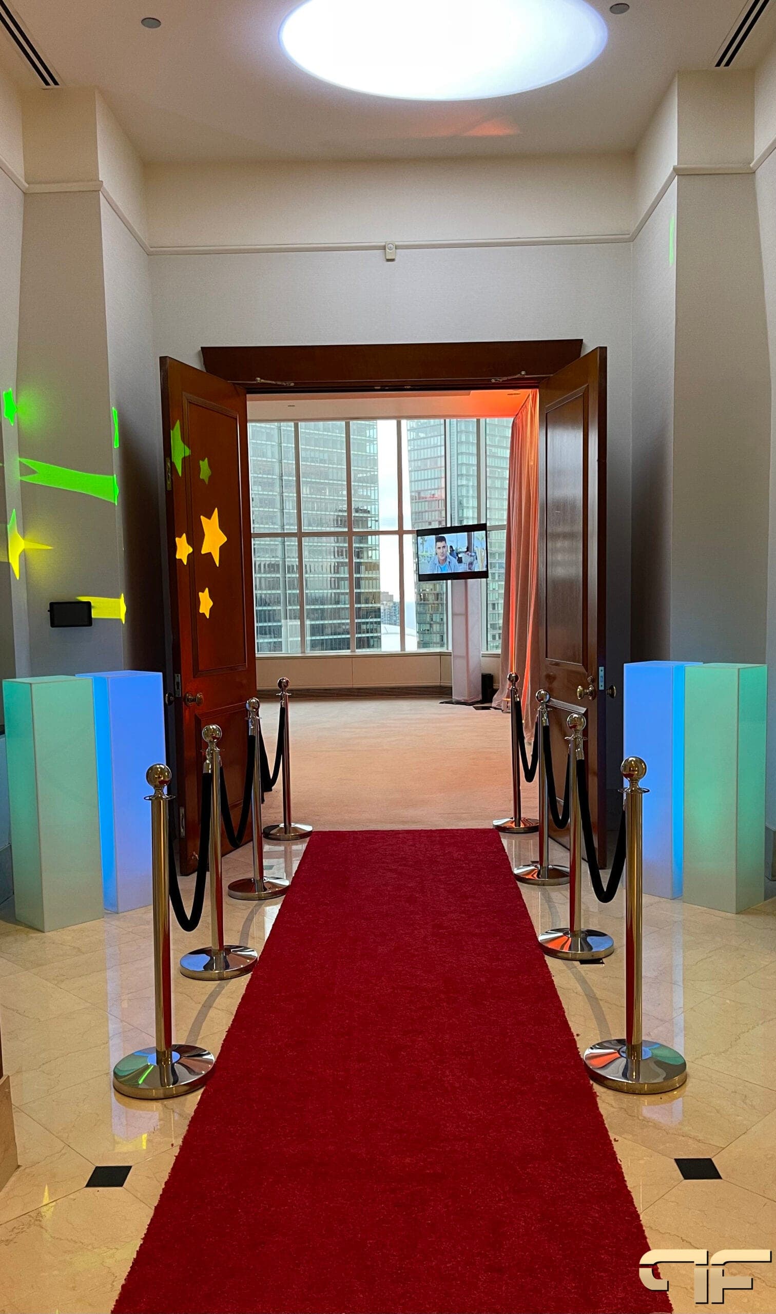 Red carpet to open doors, star and arrow gobos on walls, glowing plinths either side