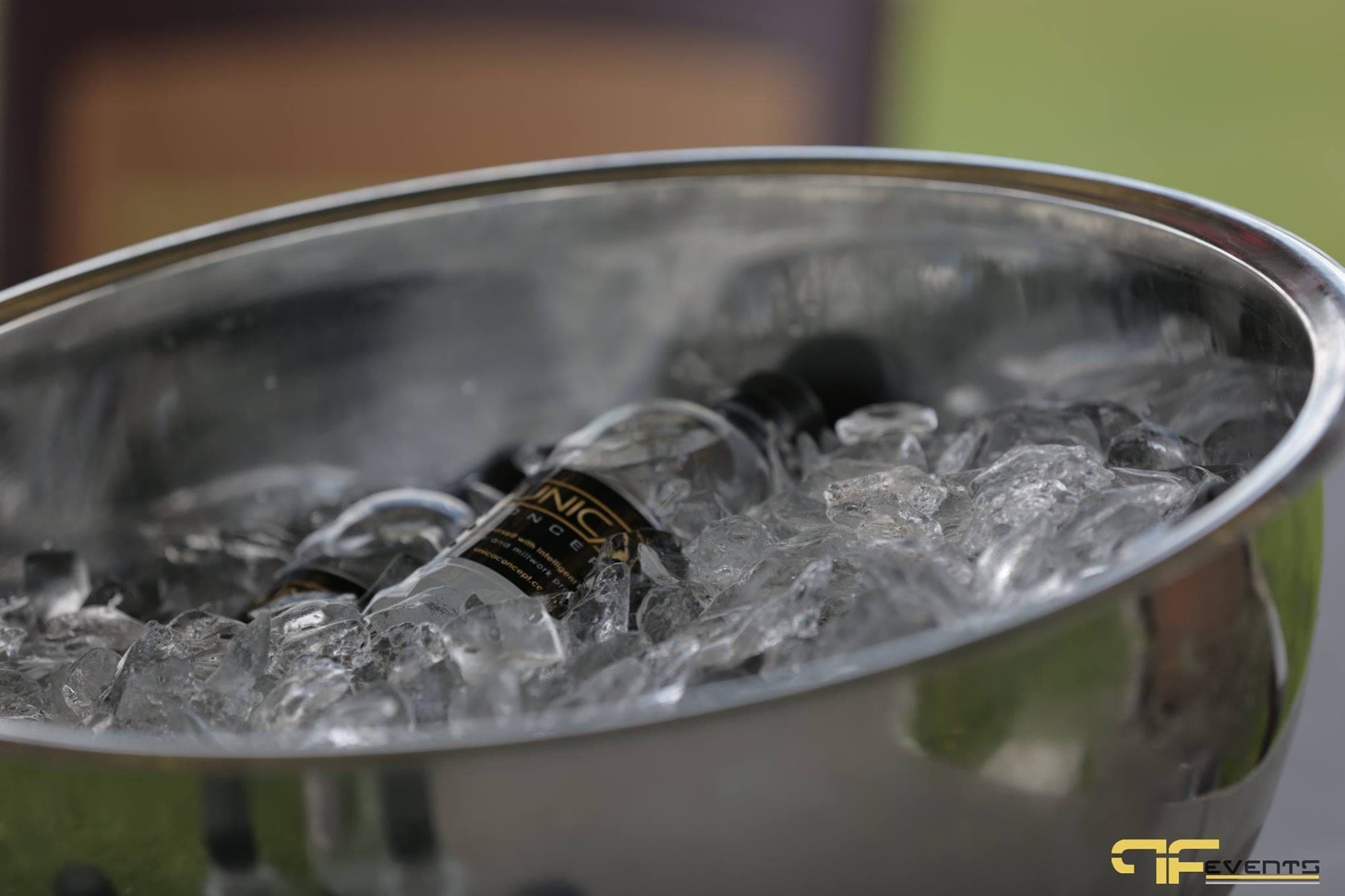 Bottled water on ice in a steel bowl at a sponsor station