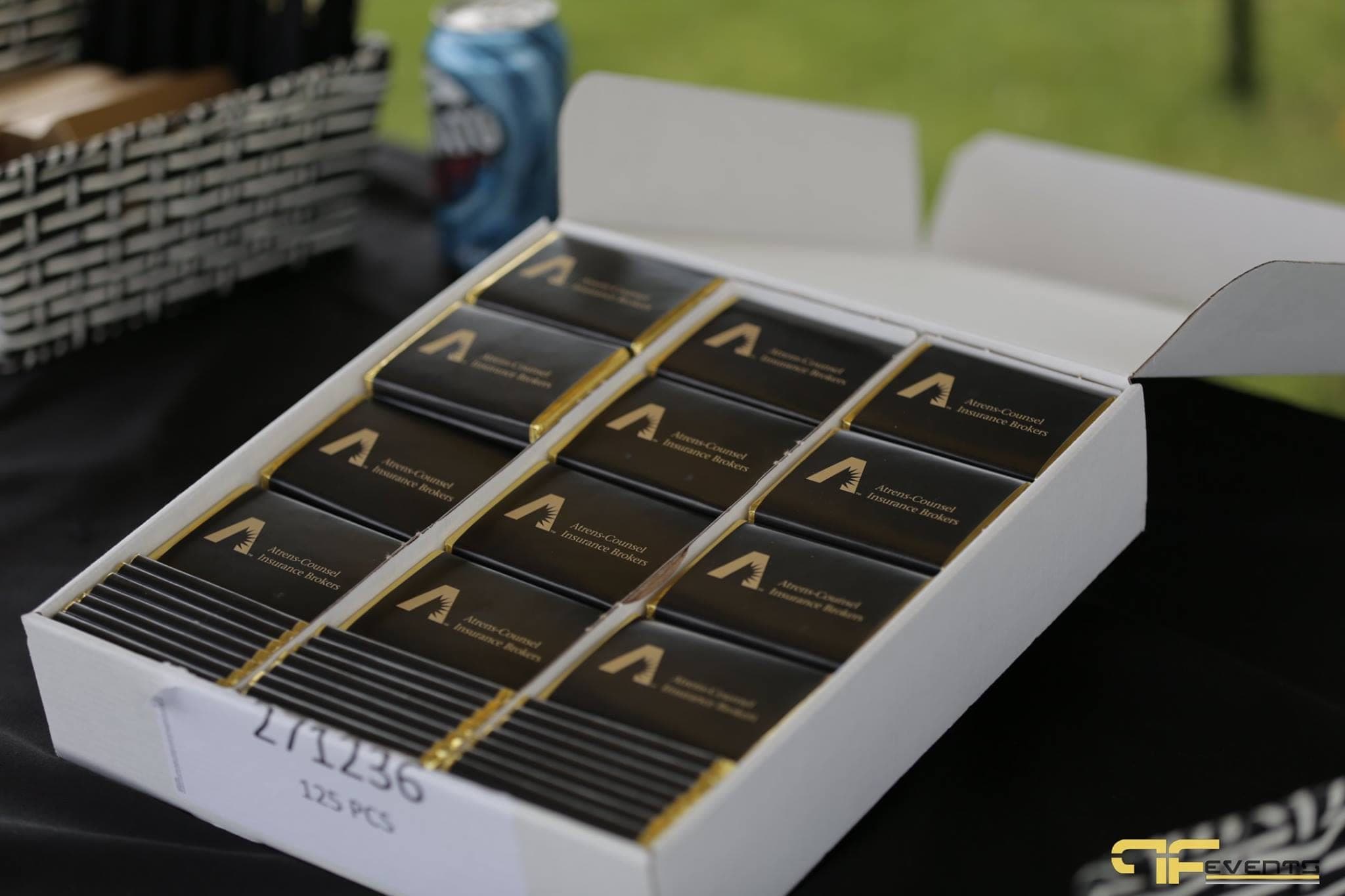 Box of sponsor-branded chocolate bars at an on-course tent