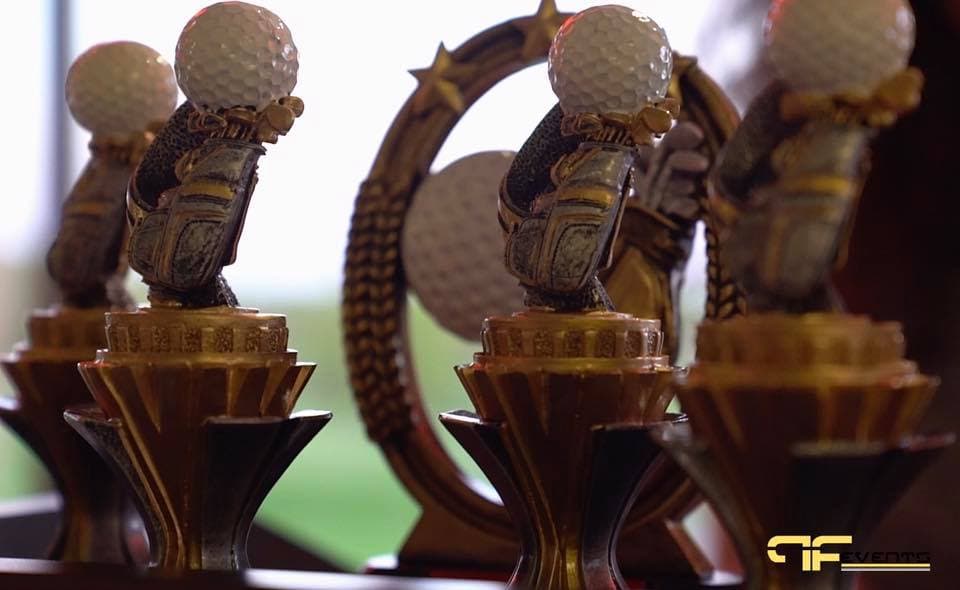 Golf trophies lined up for the tournament awards