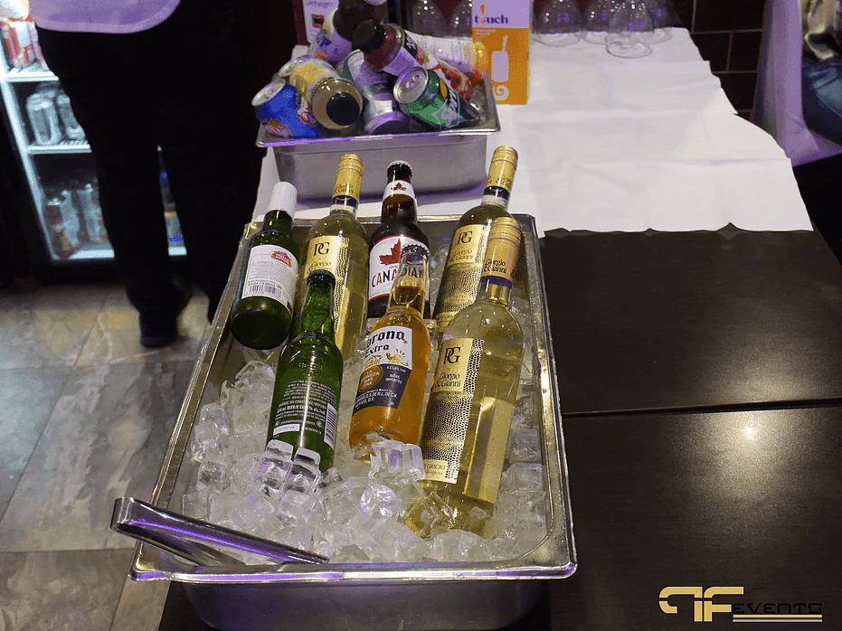 Beer and wine bottles on ice in a steel tray