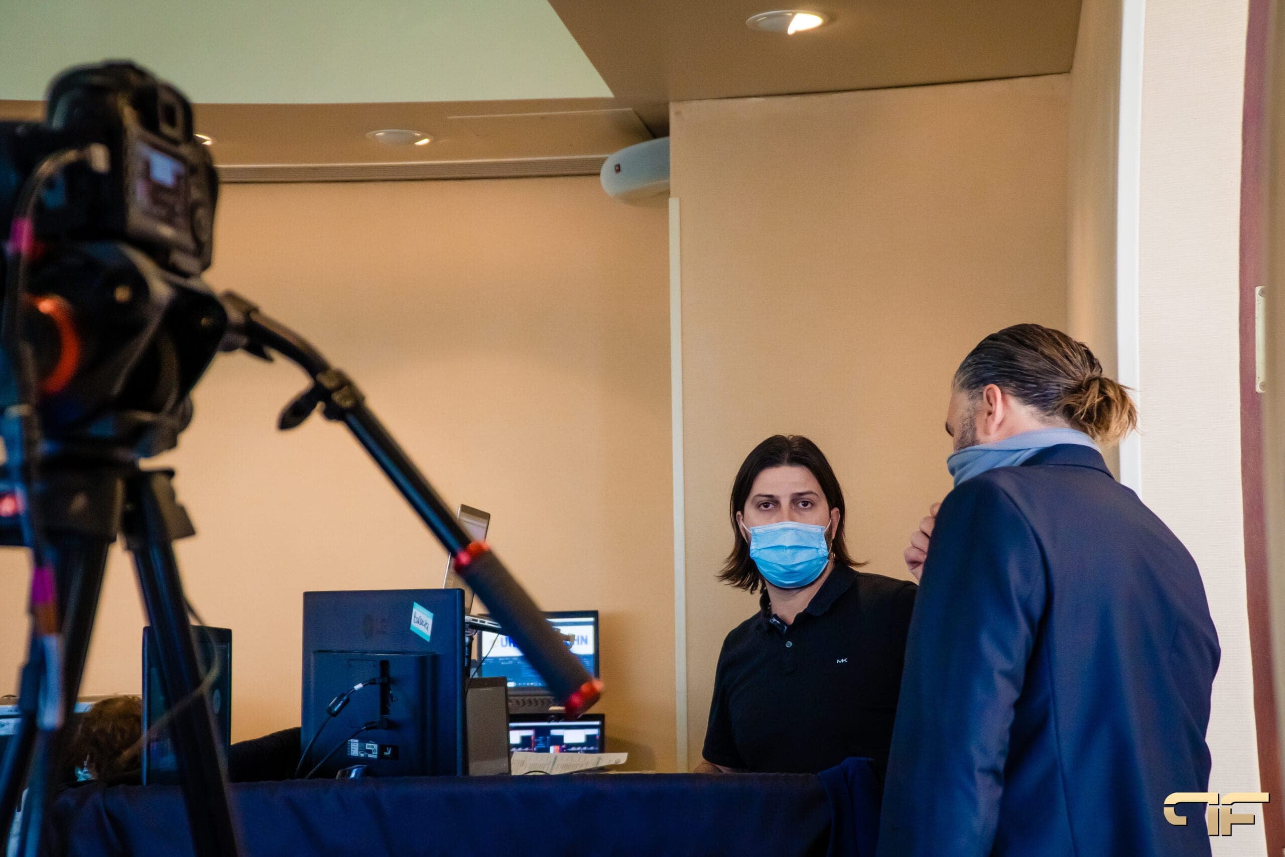 Crew in masks talk behind a camera at the UHN hybrid event