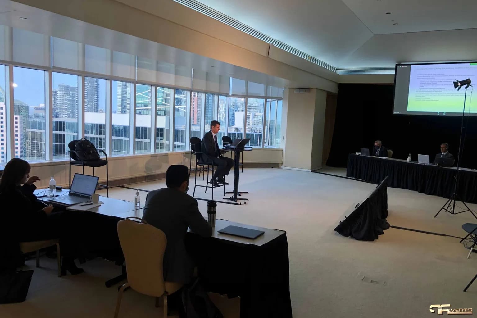 Conference room set with tables, a lectern and a projection screen for a meeting